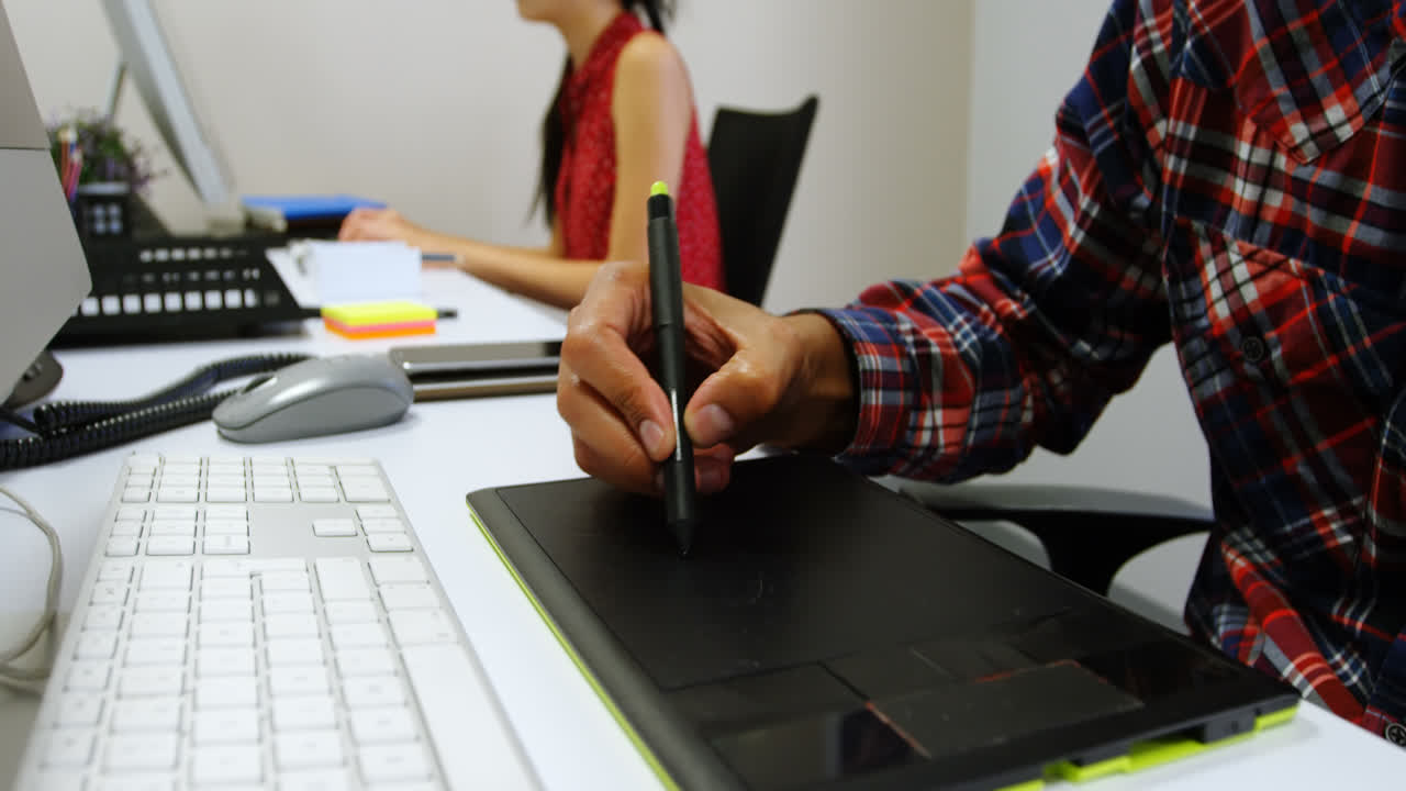 diseñador gráfico usando tableta gráfica en la oficina 4k