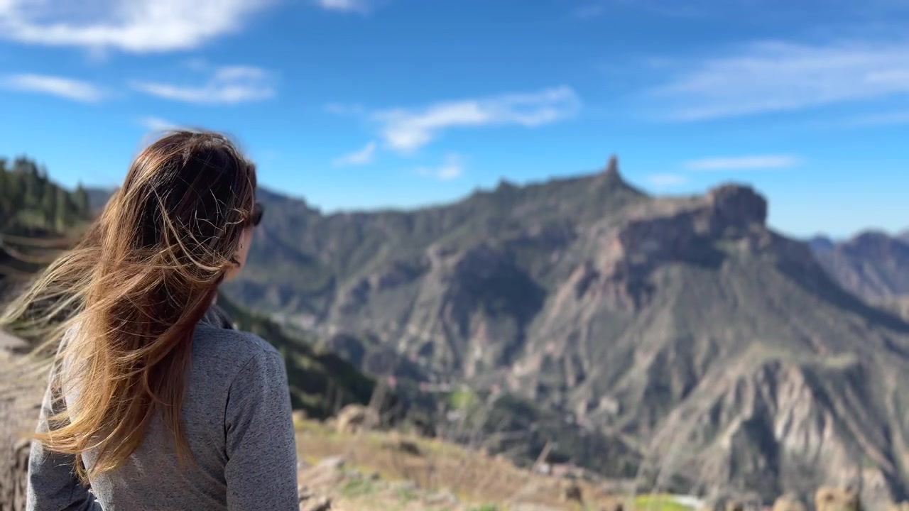 Donna avventurosa con i capelli al vento che contempla lo splendido paesaggio vulcanico di Tejeda e Roque Nublo a Gran Canaria