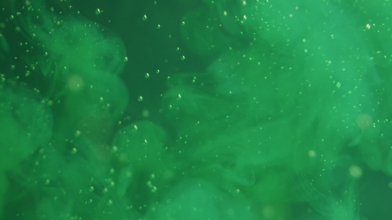 tinta verde claro que se rocía en un líquido verde