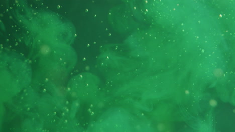 light green ink getting squirted into a green liquid