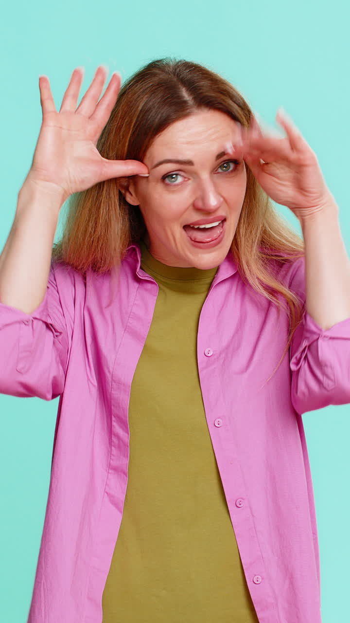 Woman sticking out tongue teasing with playful expression showing fun joke or mild mocking gesture