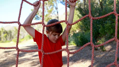 Determined-girl-climbing-a-net-during-obstacle-course