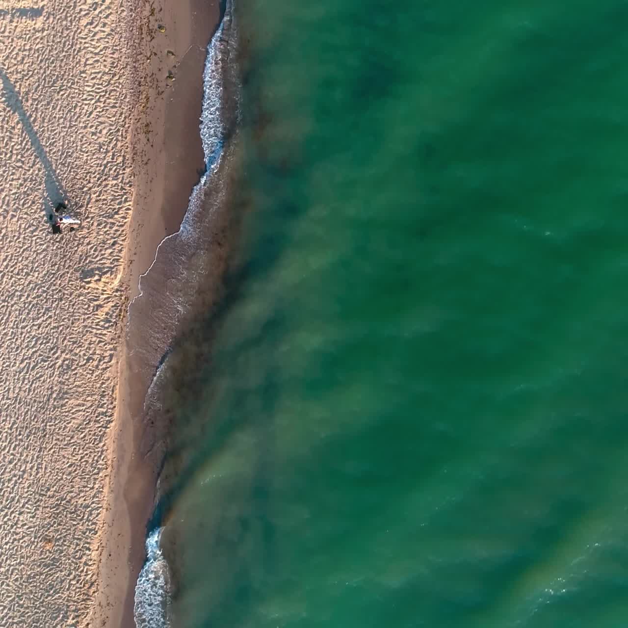 Onde del mare che si infrangono sulla spiaggia. Vista aerea dall'alto delle onde che si rompono sulla riva.