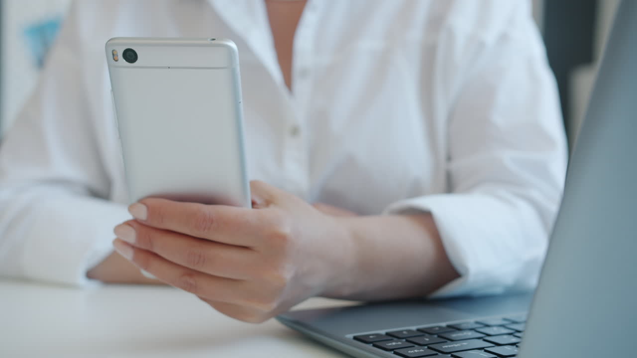 mujer usando un teléfono inteligente en su escritorio