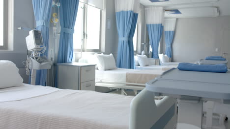 row of empty, freshly made beds and equipment in empty hospital ward, copy space, slow motion
