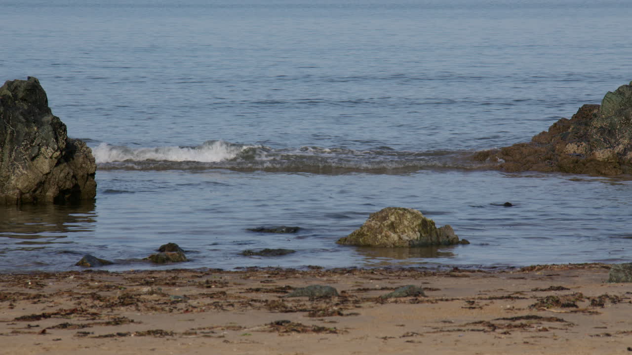 Immagine della marea che sale in una piccola insenatura nella spiaggia di Llanddwyn e nella Newborough National Nature Reserve