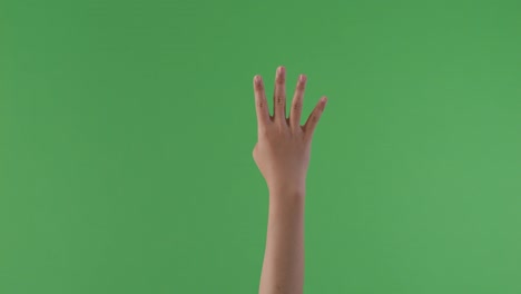 hand showing four fingers on green screen