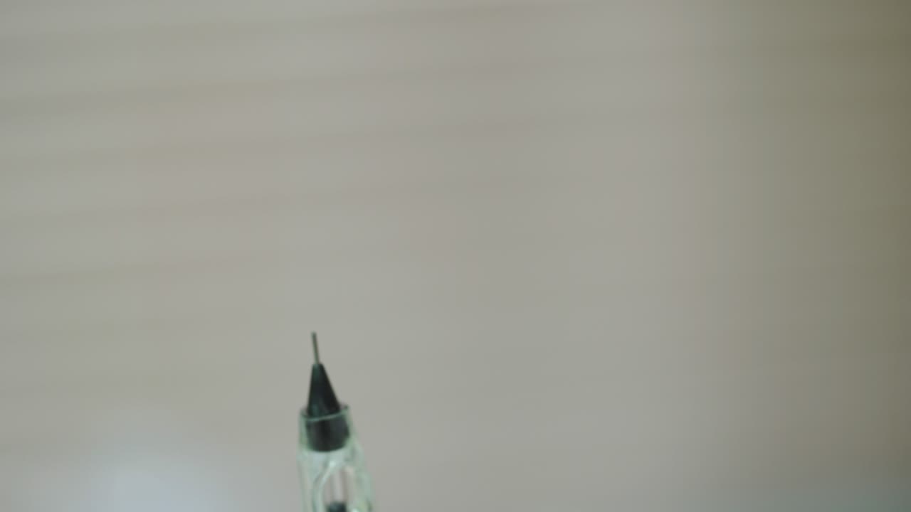 cosmetologist is holding a brush with a needle for permanent makeup of eye. Close-up. Modern methods of cosmetology. Blurred background