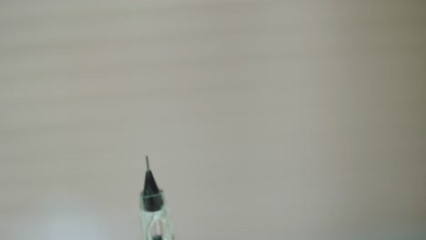 cosmetologist is holding a brush with a needle for permanent makeup of eye. close-up. modern methods of cosmetology. blurred background