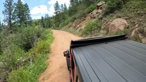 pov - view of vehicle rooftop while driving on a scenic byway in rocky mountains' front range