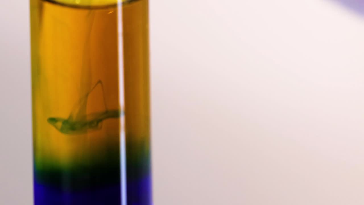 Observe the formation of distinct color layers in a test tube during a chemical reaction.