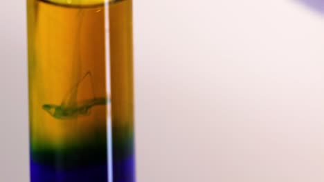observe the formation of distinct color layers in a test tube during a chemical reaction.