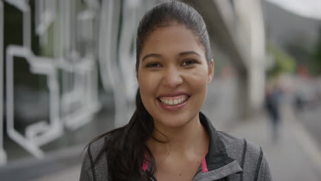 portrait-of-young-woman-commuter-laughing-cheerful-looking-at-camera-enjoying-successful-lifestyle-in-urban-city-street