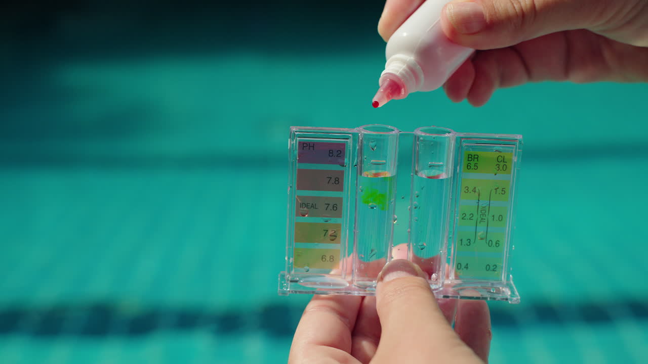 Persona que analiza la calidad del agua de una piscina para medir los niveles de pH y cloro