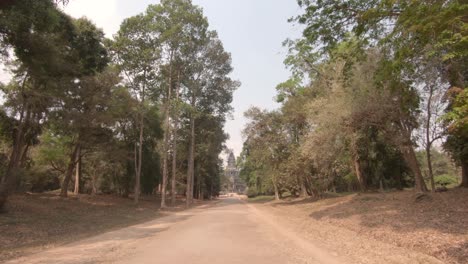 camino rodeado de árboles que conducen a angkor wat, siem reap, camboya, dolly in shot