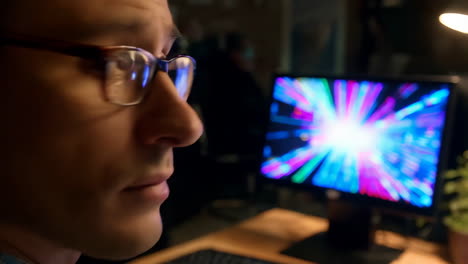 man looking at a computer screen at night