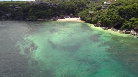 AERIAL-DOLLY-FORWARD-VIEW-of-PADANG-PADANG-BEACH,-one-of-Bali’s-most-famous-spots