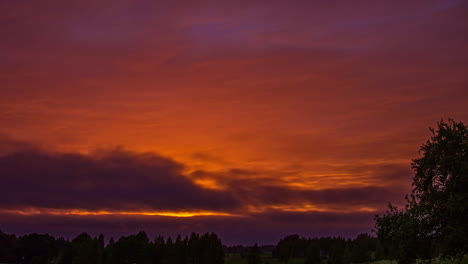 Tiro-De-ángulo-Bajo-Sobre-El-Cielo-Rojo-Del-Atardecer-Con-Movimiento-De-Nubes-Oscuras-En-Timelapse