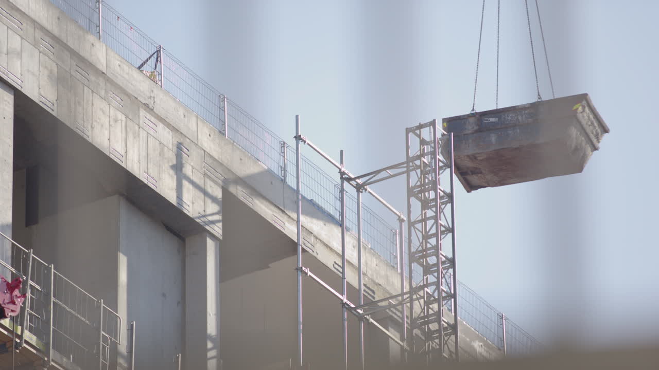 Crane moving construction skip at New Government quarter construction site, Oslo