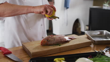 caucasian female chef preparing a dish and smiling in a kitchen