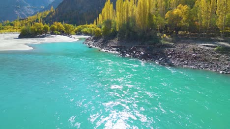 Aerial-pullback-view-turquoise-water-lake-flowing-calmly-in-Skardu-Valley,-Pakistan