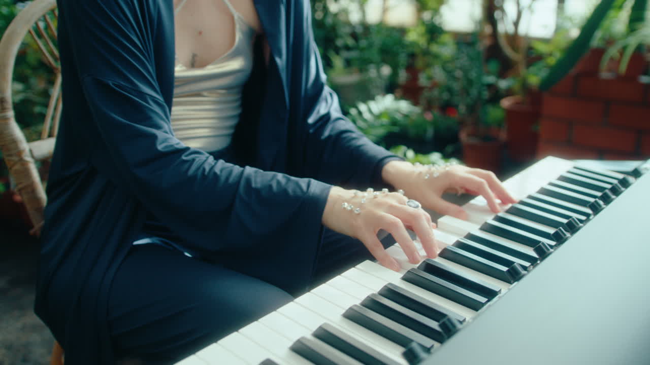 Focused Female Musician Playing Keyboard in Sunlit Greenhouse