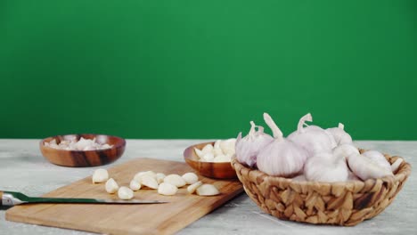 male hand puts the peeled garlic cloves on a cutting board.