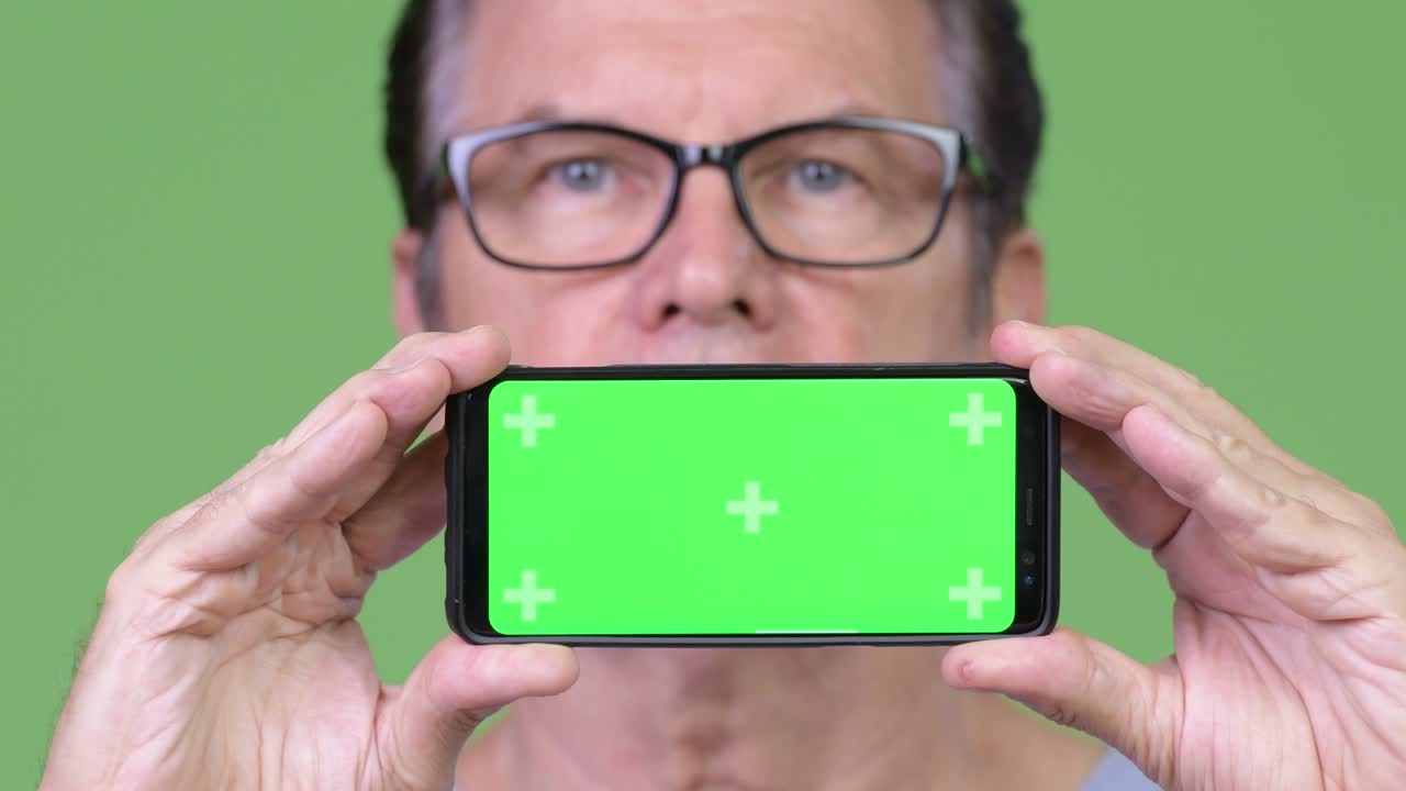 Senior handsome man showing phone