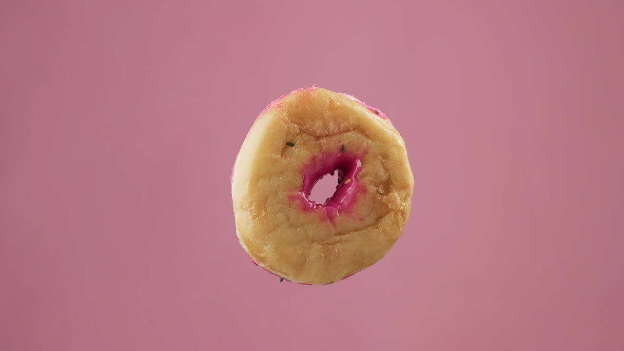 rosado con frasco donut con salpicaduras en fondo rosa. volando dulce postre.