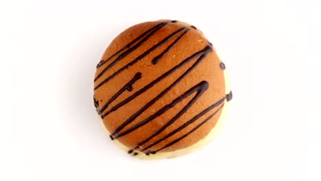 top view of sweet doughnut rotating at white background. fresh donut spinning