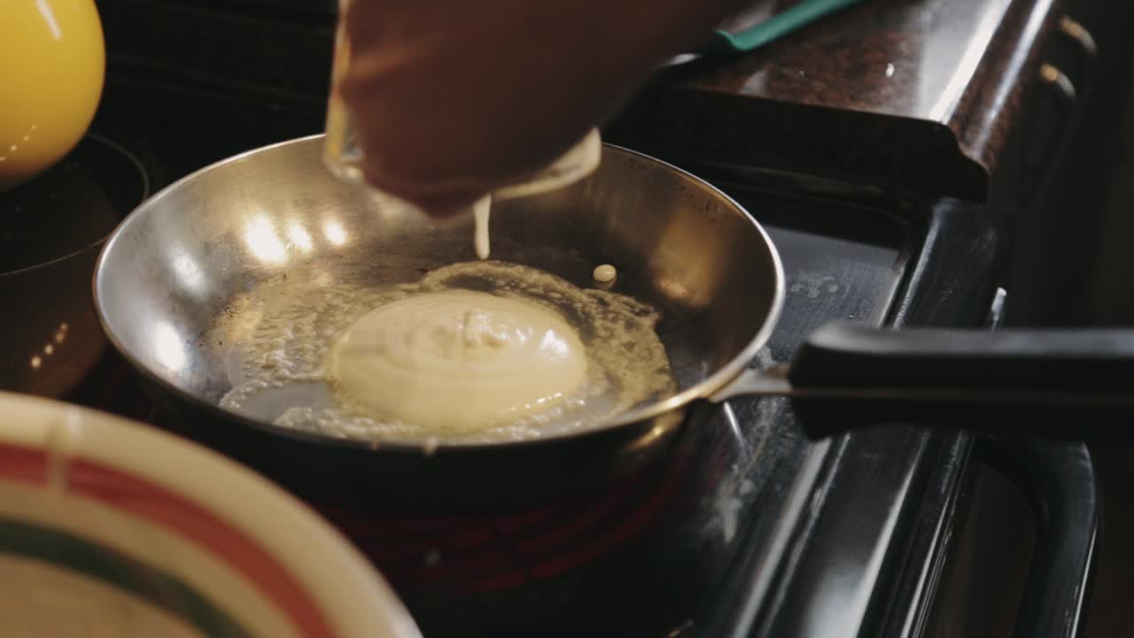 Pouring The Pancake Batter Using A Glass Pitcher Into The Hot Skillet - Close Up Shot