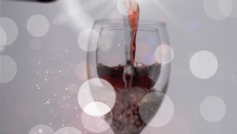 animation of red wine pouring into glass on background with lights