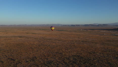 flying near a single hot air balloon over arizona desert landscape