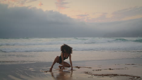 woman sensual dance beach wet sand cloudy evening. girl performing contemporary.