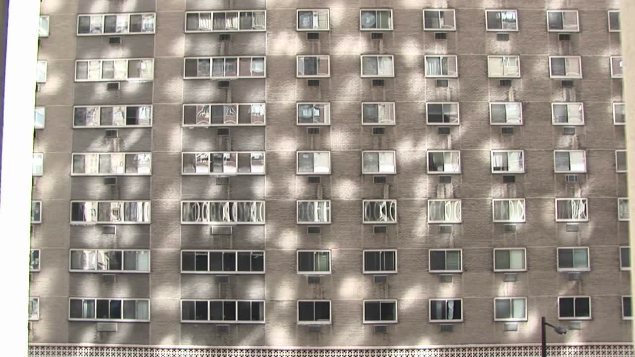 en stor lejlighed eller hotel udvendig giver et interessant baggrundsmønster fra reflekteret sollys og den regelmæssige placering af sine vinduer