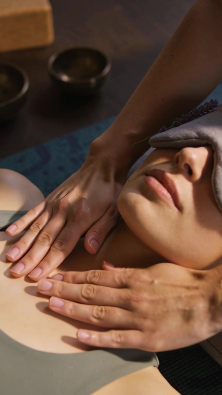 Vertikal video: Efter at terapeuten har placeret en øjenpude, får klienten i en tank bryst- og nakkemassage på et spa.