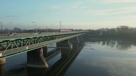 cars, a tram and a train cross the gdanski bridge during a morning