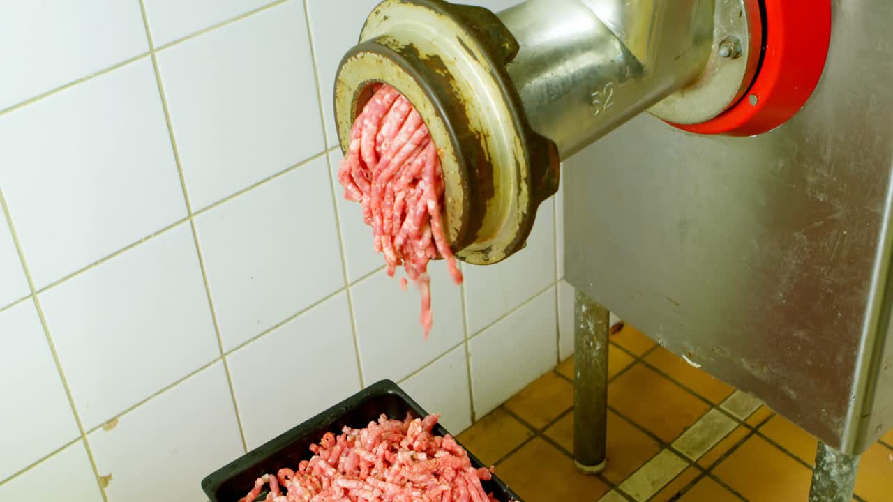 macellaio che fa la carne macinata nella macchina per macinare la carne 4k