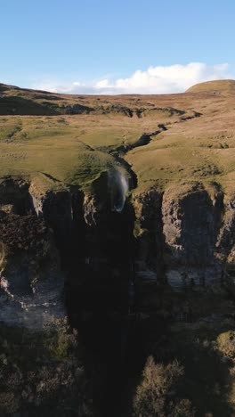 breathtaking 4k vertical drone shot of devil's chimney blowing the water backwards up of the cliff - co.sligo - ireland 01