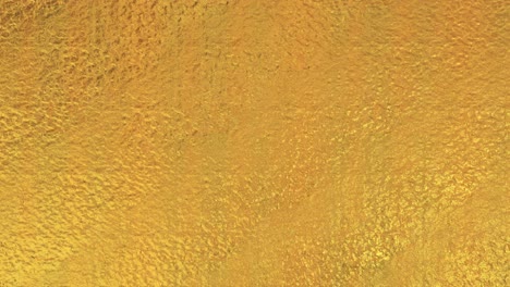 golden foil background. gold texture 3d rendering loop 4k