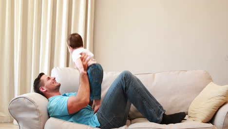 Father-playing-with-his-baby-boy-on-the-couch