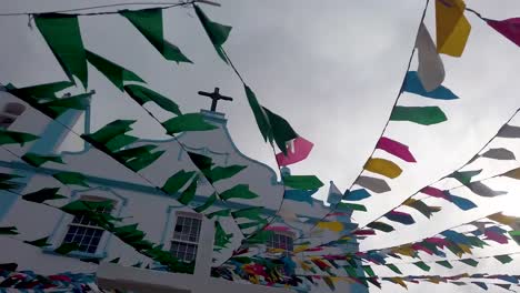 exterior shot capturing the church of our lady of light adorned with a vibrant array of multicolored flags, morro de sao paulo, bahia, brazil