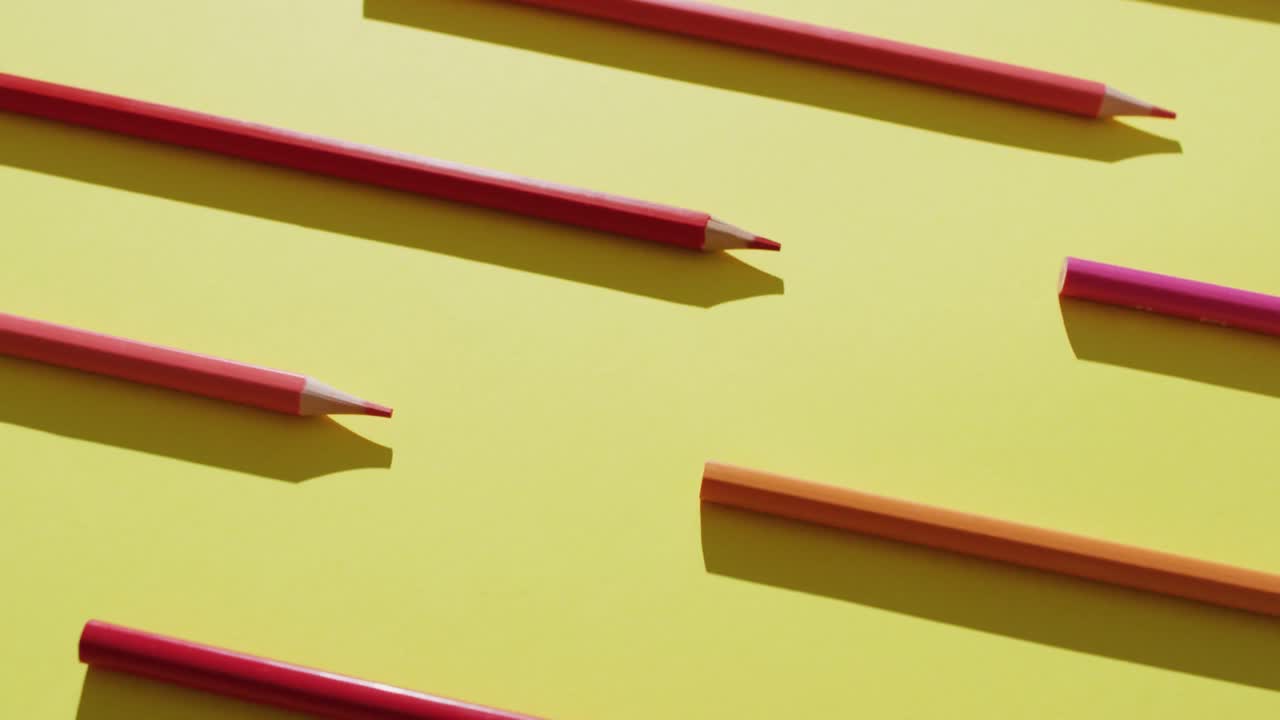 노란색 배경에 줄지어 있는 다채로운 크레이온의 비디오