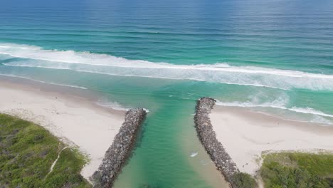 drone flyover of river meeting the ocean