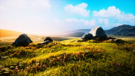 meadow-with-huge-stones-among-the-grass-on-the-hillside-at-sunset