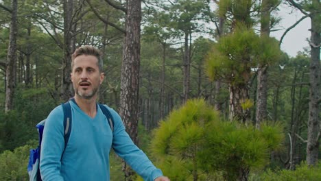 male hiker walking in forest