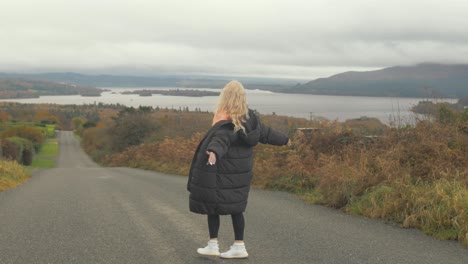 Atractiva-Mujer-Rubia-Girando-Frente-A-La-Vista-Del-Lago