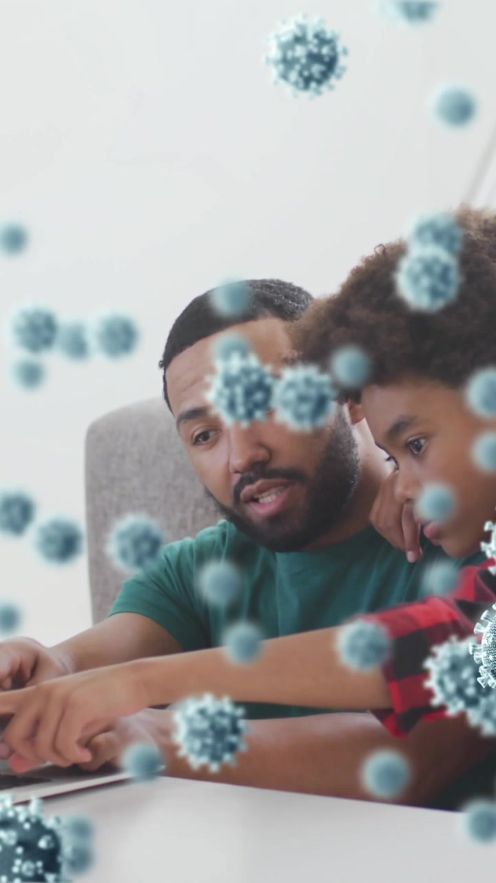 Animazione di cellule virali su un padre afroamericano con il figlio che usano il laptop
