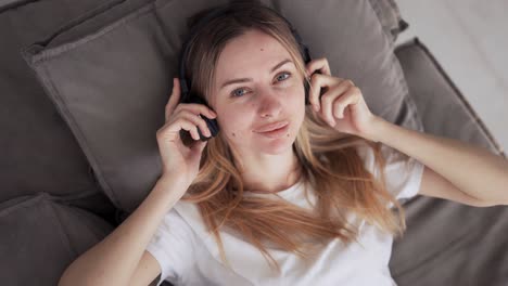 Mujer-Relajándose-Y-Disfrutando-De-La-Música-Con-Auriculares-En-El-Sofá