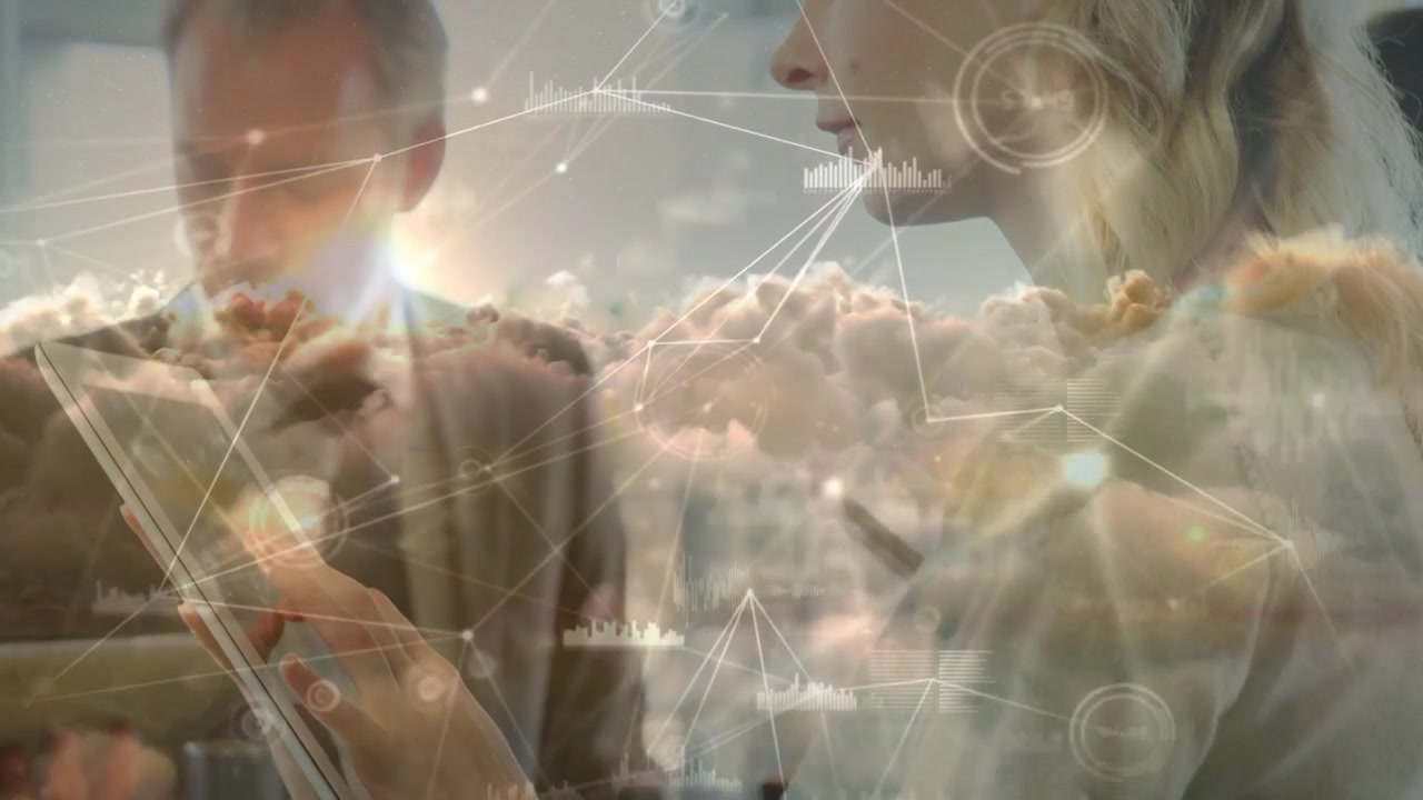 Frau tippt auf ein Tablet, startet ein wachsendes Cloud-Overlay, das das Team vernetzt, während ein Mann Geschäftsdaten analysiert.